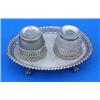 A George III oval inkstand with gadrooned and pierced borders on four ball and claw feet, with a cut