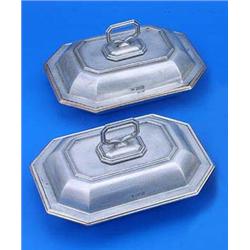 Two canted rectangular entree dishes, covers and handles each with moulded borders, one with a crest