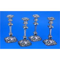 A set of four William IV shaped-square raised candlesticks, with shell and leaf chased capitals and.
