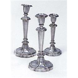 A set of four 19th century candlesticks with shaped round capitals, tapering stems and flower shaped