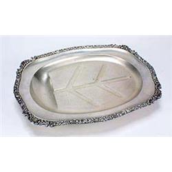 A 'well and tree' meat dish, shaped oblong with a flower, shell and scroll chased border on ball fee
