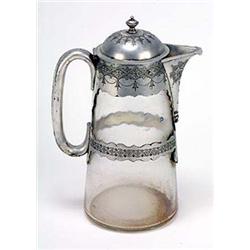 A straight tapering glass jug with engraved mounts and loop handle, the domed cover with knopped fin