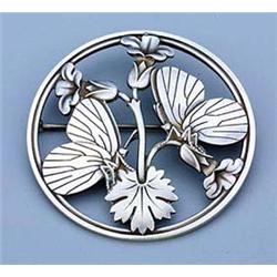 A Georg Jensen silver circular brooch, having an openwork design of two butterflies resting on a flo