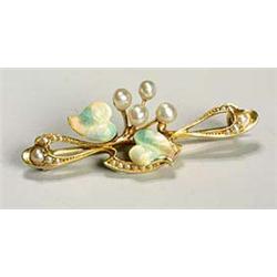 An Art Nouveau enamelled gold and pearl brooch, of sinuous outline set with seed pearls and having t