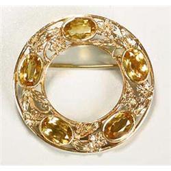 An Arts and Crafts gold and citrine circular brooch, by Shipton & Co., having five oval and facetted