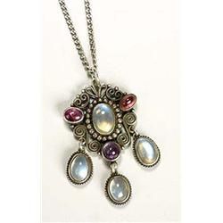 An Arts and Crafts moonstone and amethyst pendant, with a central moonstone cabochon within a beaded