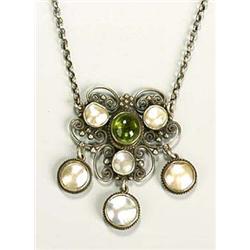 An Arts and Crafts peridot and mother of pearl pendant, having a central peridot cabochon flanked by