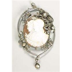 An Arts and Crafts pendant/brooch, centred with an oval shell cameo depicting two classical figures,