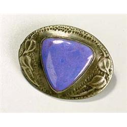 A Ruskin Pottery triangular plaque mounted as a brooch, of lavender tone and mounted in an oval pewt