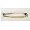 A gold and turquoise brooch, resembling a safety pin, set at each end with a small turquoise cabocho