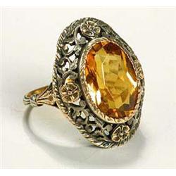 An Arts and Crafts citrine ring, with the central oval and facetted stone, held within an openwork f