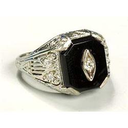 A stylish diamond and black onyx ring, having a rectangular plaque with canted corners with a centra