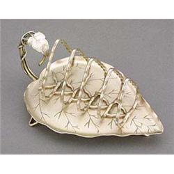 A Hukin & Heath plated toastrack, of leaf shape with a curved foliate handle, and with graduated alm