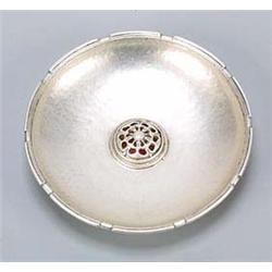 An Omar Ramsden silver and enamel small dish, with planached surface and a notched rim, centred with