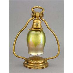 A Tiffany Studios table lamp, the textured and gilded bronze base of circular domed shape with curve