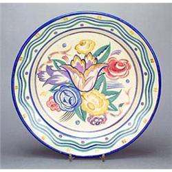 A Poole Pottery circular dish, designed by Truda Carter, painted in bright colours in the centre wit