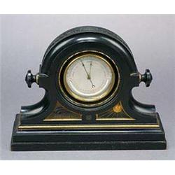 A late 19th Century ebonised and gilt mantel barometer, the instrument in a circular case with carve