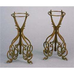 A pair of Art Nouveau bronze fret-work stands, each formed from two flat sections, cut in a sinuous.