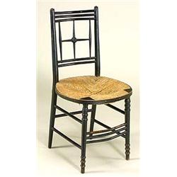A pair of Morris & Co. ebonised 'Sussex' chairs, with open star-like backs, oval rushed seats, on tu
