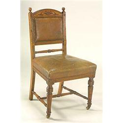 A pair of late 19th Century oak upright chairs, with curved toprail having intaglio decoration of a.