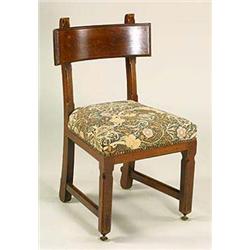 A Gothic revival oak upright chair after a design by A .W. N . Pugin, having a broad horizontal back
