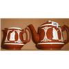 An early C20th terracotta teapot and jug with cream relief decoration