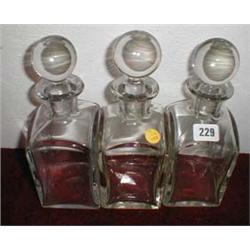 A set of three c1920's heavy glass decanters