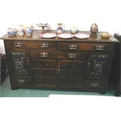 A C19th oak Arts and Crafts side board with copper relief decorated panels to doors with copper & br