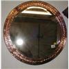 An Arts & Crafts bevel edged circular mirror with copper surround
