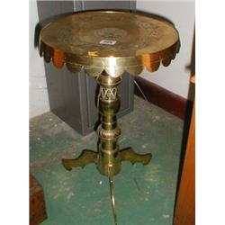 An Eastern brass table on tripod base with chased decoration
