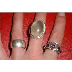 A silver band ring together with two other dress rings with stone settings