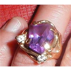 A gold ring with purple and diamond stones