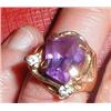 A gold ring with purple and diamond stones