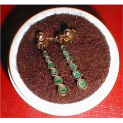A pair of gold earrings with green stones