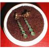 A pair of gold earrings with green stones