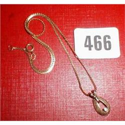 A diamond and gold horse shoe pendant