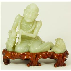 CHINESE GREENISH-WHITE JADE FIGURE OF AN ASCETIC