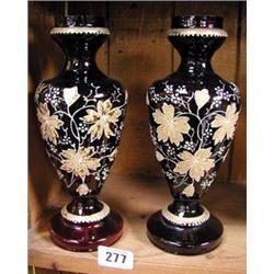 A pair of red glass vases with gilt and white floral decoration.