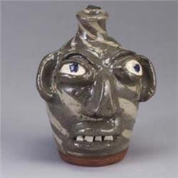 Fine B.B. CRAIG alkaline swirl face jug in two-tone grey, with blue eyes, under a glossy glaze. Stam