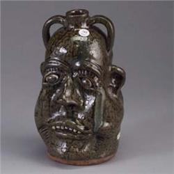 Fine LANIER MEADERS stoneware face jug, ca. 1990, with a misshapen face and seven teeth, and covered