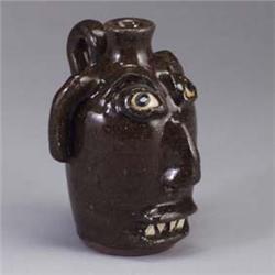 DWAYNE CRAIG face jug covered in a speckled brown glaze. Signed Dwayne Craig. 8" x 5 3/4" Est.  500