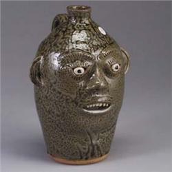 A.G. MEADERS face jug, 1990, incised with expressive eyebrows and eyelashes, and covered in a drippi
