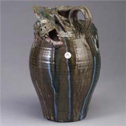 Tall J. FLOWERS stoneware jug, 1997, with large applied dragon, covered in pink, blue, and green dri