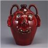 Image 1 : A.V. SMITH face jug covered in a candy apple red glaze, with bulging blue eyes. Signed AV SMITH. 11