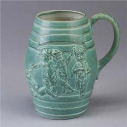 ROOKWOOD Cooperage beer mug with figures, 1943, covered in a pale green glaze. Flame mark. 8" Est.