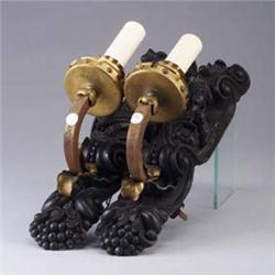 Pair of Gothic candle sconces, the back plate carved with scrolls and figures, with brass-washed bra