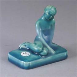ROOKWOOD paperweight, 1952, with nude figure covered in a glossy teal glaze. Repaired crack through