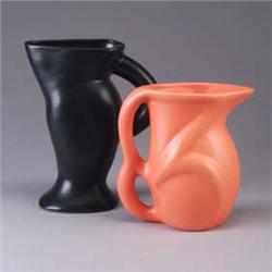 Two contemporary pitchers, one in a bright orange glaze, the other by "Stella" in black. Both marked