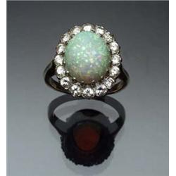14-Karat Yellow and White Gold, Opal and Diamond Dinner Ring Circa 1950 Set with an oval cabochon...