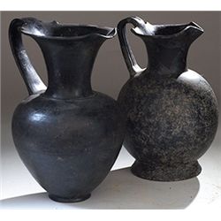 Vases. Two Etruscan bucchero-ware oinochoai. Circa 7th - 6th century BC.  D/ 27 cm and 28 cm high.  